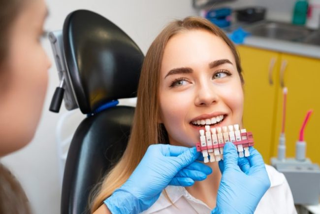 Dentist,Selects,A,Shade,Of,Teeth,Whitening,Using,Shade,Guide Cosmetic Dentistry taylorsville