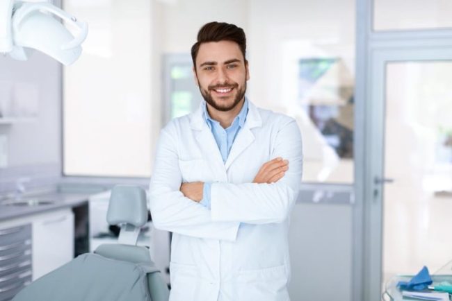 Young,Man,Dentist,Posing,At,Modern,Dental,Cabinet,,Standing,Next dentist near taylorsville
