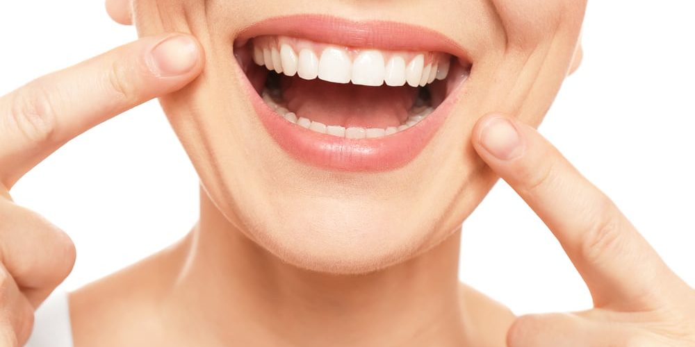 Transform Your Confidence With a Smile Makeover Near Me — woman pointing to her even smile