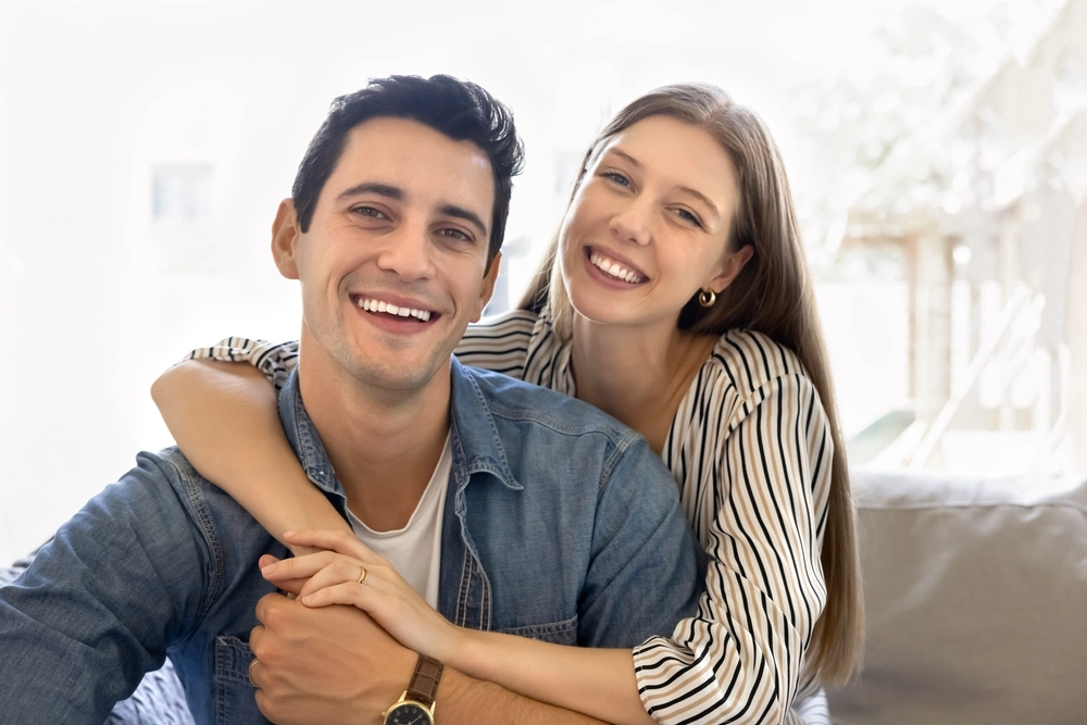 Smiling couple embracing at home