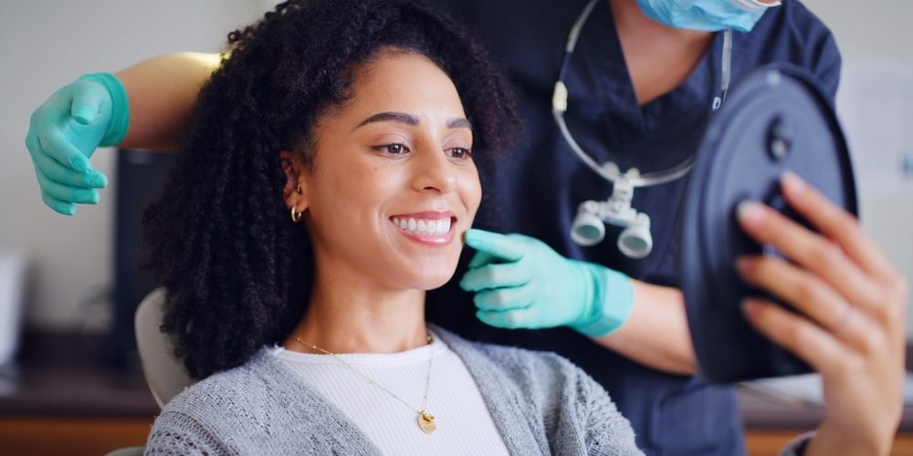 Ready for a Taylorsville Dentist You’ll Look Forward to Seeing? — patient checking her smile in a mirror